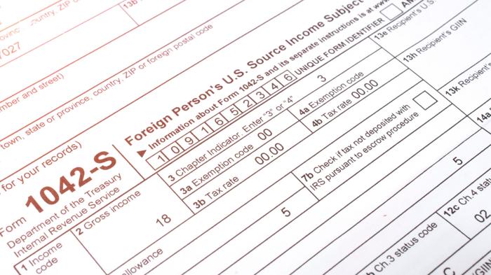 Close-up of IRS Form 1042-S for reporting U.S. source income by a foreign person, used in Canadian tax context.