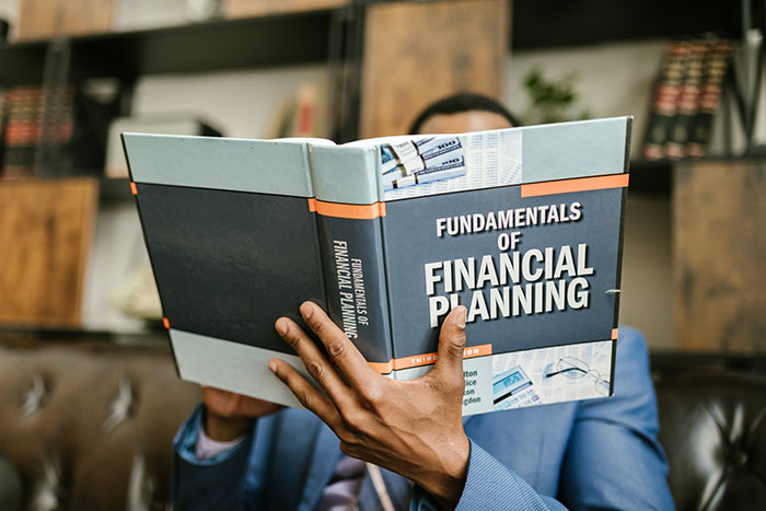 Man reading a book on the fundamentals of financial planning