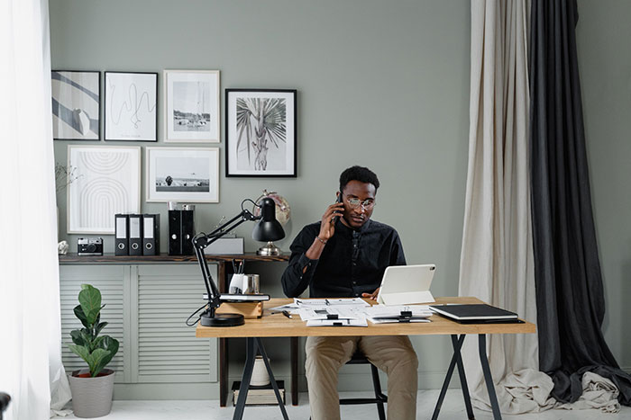 A self-employed entrepreneur works at a desk in his home office.