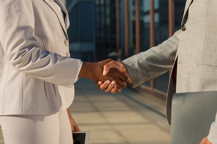 Businesswoman shaking hands with male partner