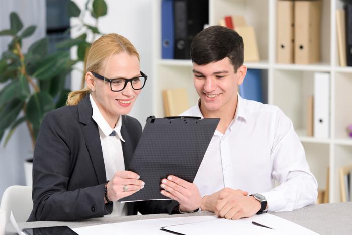 Accountant and her client smiling while looking at a clipboard