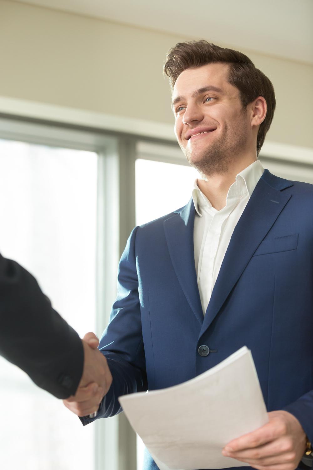 Smiling man shaking hands with another person Smiling man shaking hands with another person