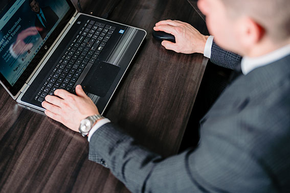 Sam Faris sitting at desk viewing website homepage for Faris CPA on laptop