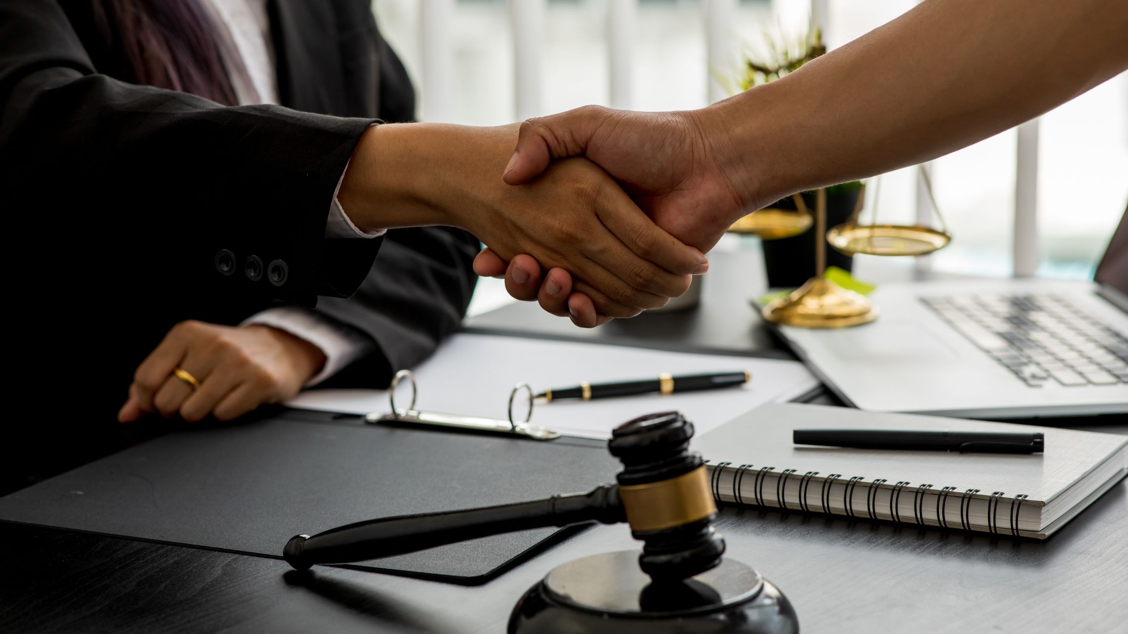 Handshake between a client and tax professional at a law office, symbolizing legal support during a CRA audit or investigation