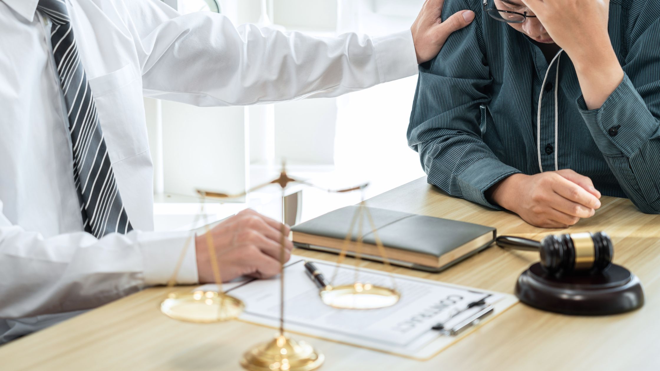Tax professional consoling a stressed client at a legal desk with documents and a gavel, representing CRA audit support.